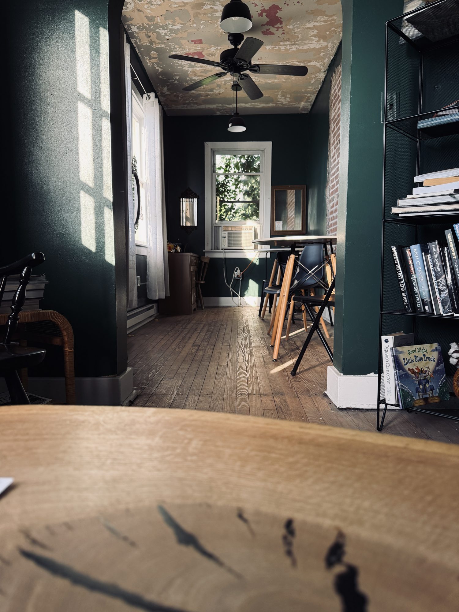 A sunlit quiet room with books and wooden floors